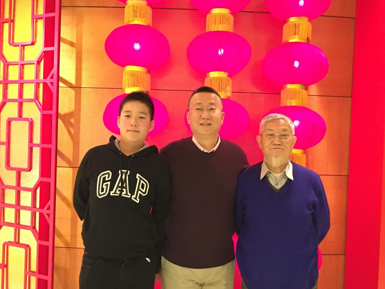 A younger Jacob and his dad, Huey, with a family member under red lanterns.